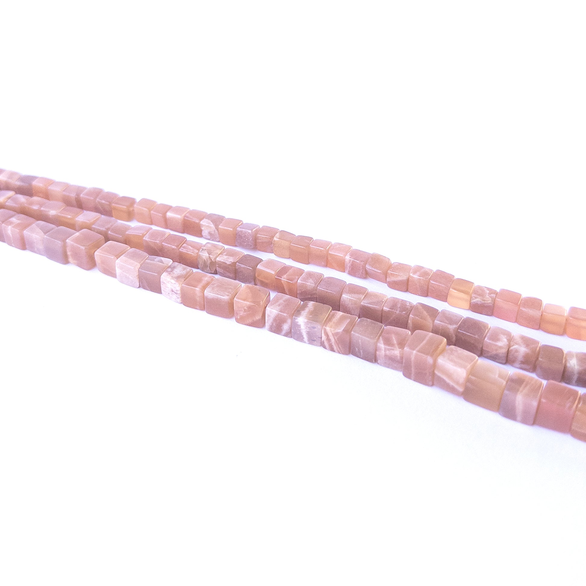 Handmade jewellery components featuring natural sunstone smooth cube beads in a neatly aligned strand.