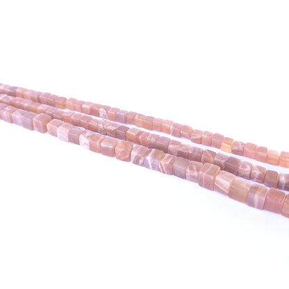 Handmade jewellery components featuring natural sunstone smooth cube beads in a neatly aligned strand.