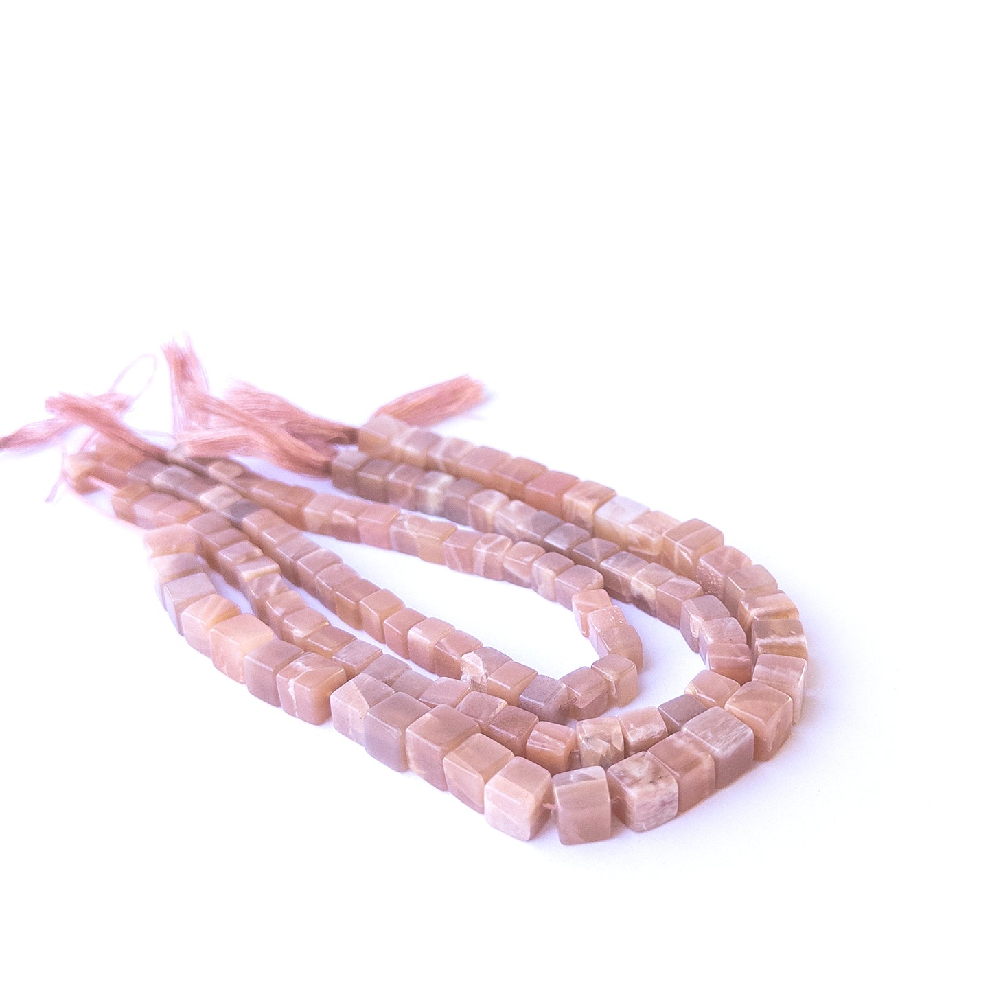 Authentic sunstone gemstone beads showcasing warm peach‑orange tones and uniform cube cuts.