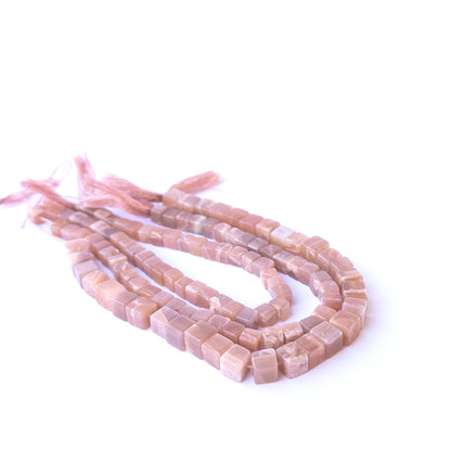 Authentic sunstone gemstone beads showcasing warm peach‑orange tones and uniform cube cuts.