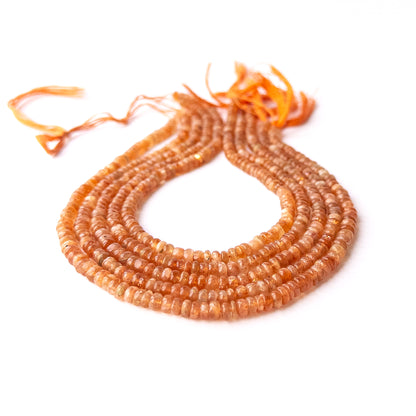 Strands of Sunstone smooth rondelle gemstone beads arranged neatly, showcasing their smooth finish and subtle sparkle.