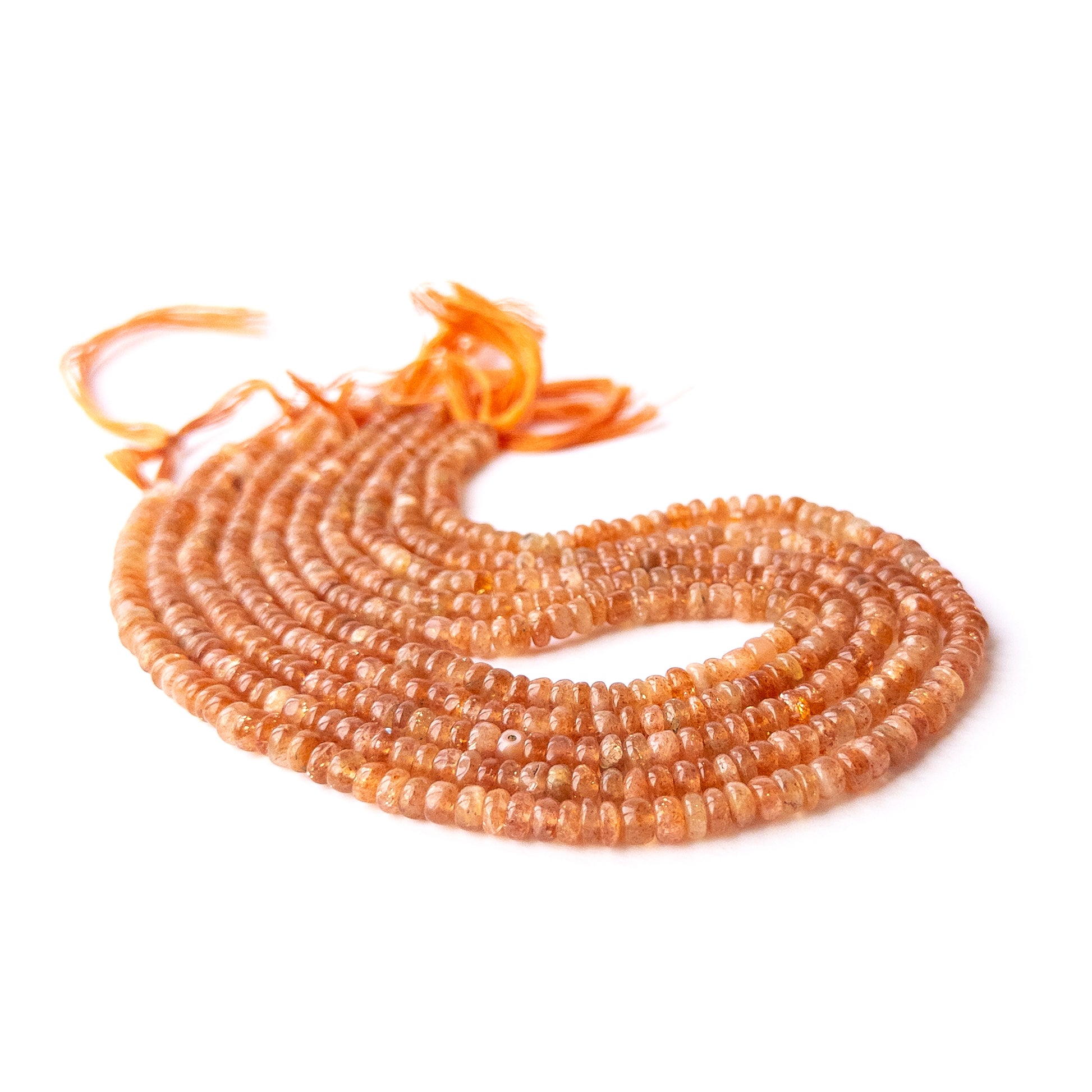 Sunstone smooth rondelle beads displayed in multiple strands, showing consistent sizing and natural variation.