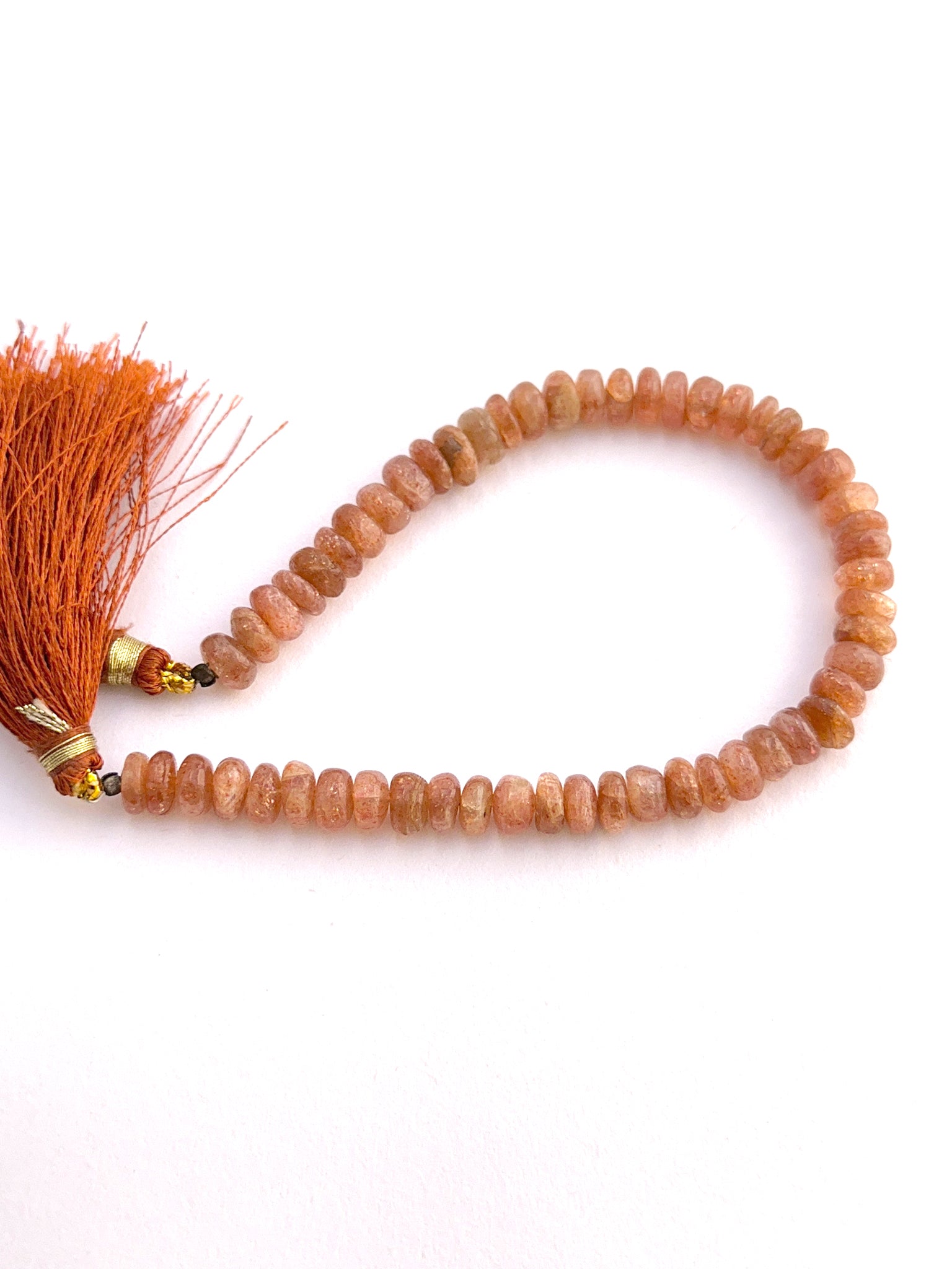 Close-up of natural gemstone beads showing smooth finish and radiant colour.