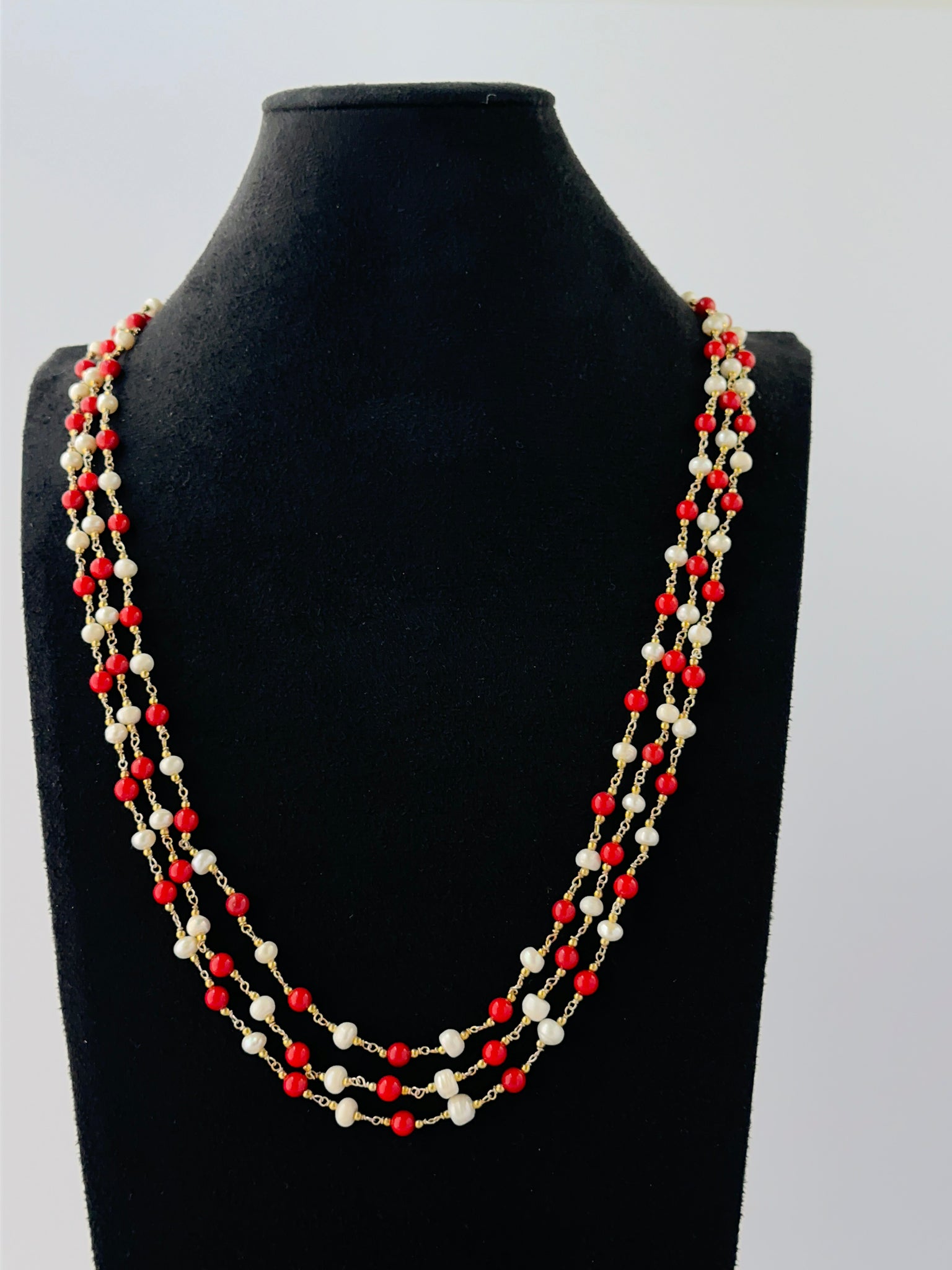 Elegant triple-strand coral and pearl necklace featuring smooth round beads in 48-52cm lengths.