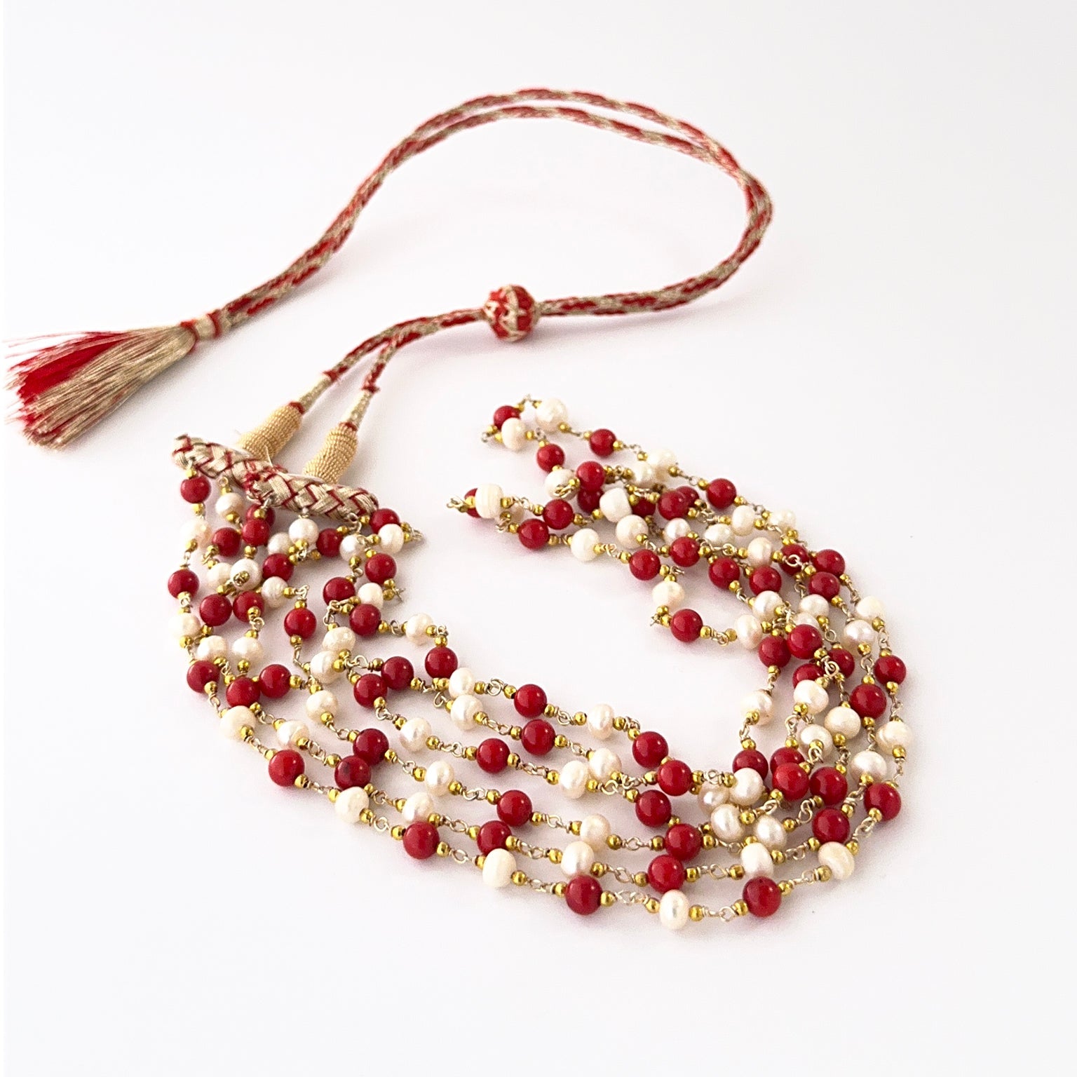 Multi-strand Taiwan coral and freshwater pearl necklace arranged in soft graduated layers.