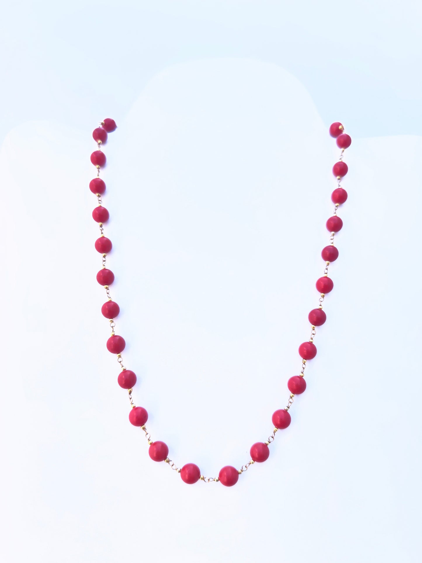 Close-up of Taiwan Coral gemstone beads, smooth round cut, polished finish, arranged in a strand.