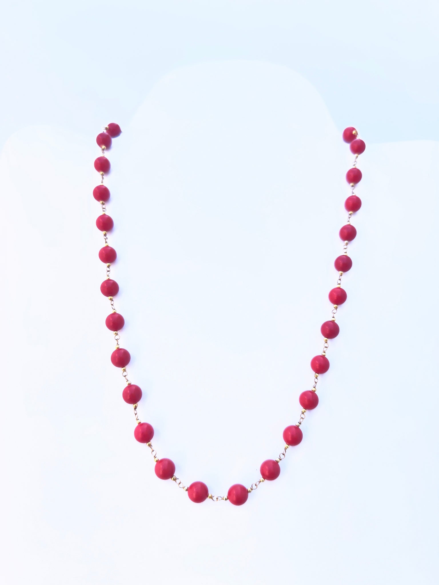 Close-up of Taiwan Coral gemstone beads, smooth round cut, polished finish, arranged in a strand.