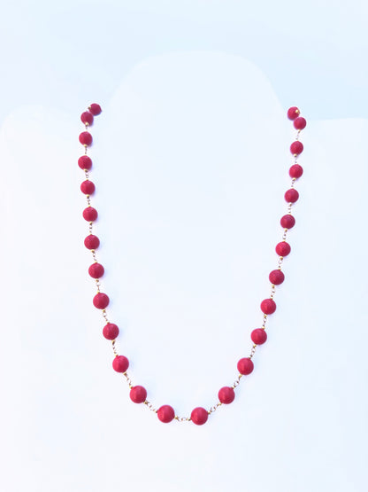 Close-up of Taiwan Coral gemstone beads, smooth round cut, polished finish, arranged in a strand.