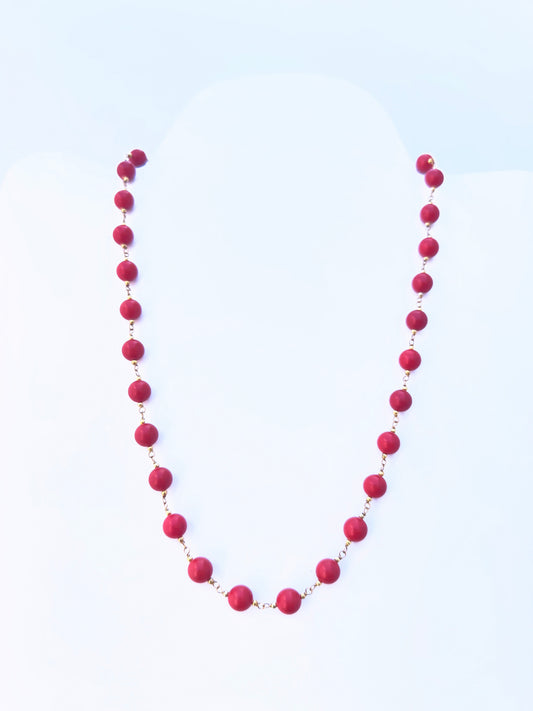 Close-up of Taiwan Coral gemstone beads, smooth round cut, polished finish, arranged in a strand.