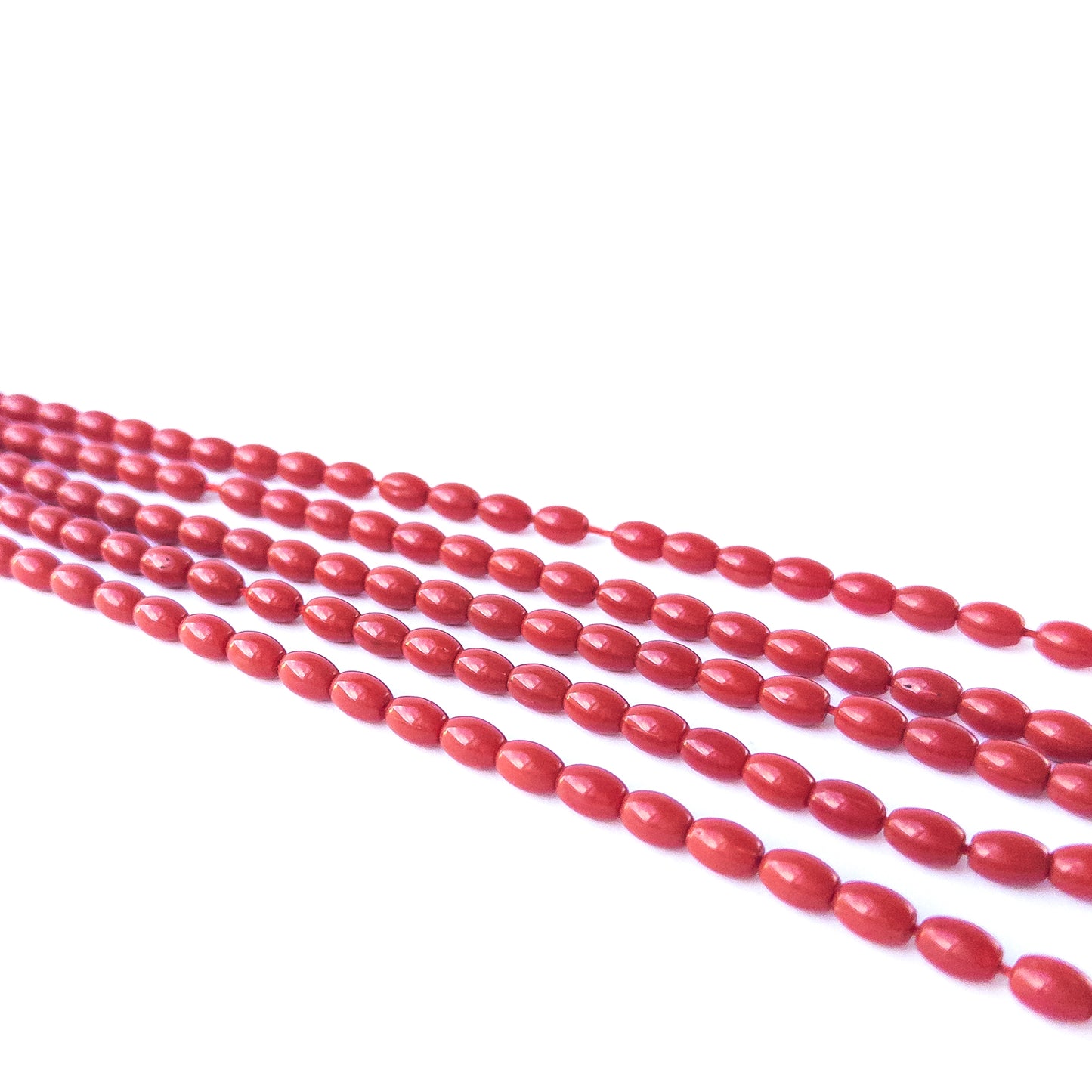 Close‑up of Taiwan Coral smooth drum beads showing warm tones, smooth shaping and high‑quality gemstone detail.