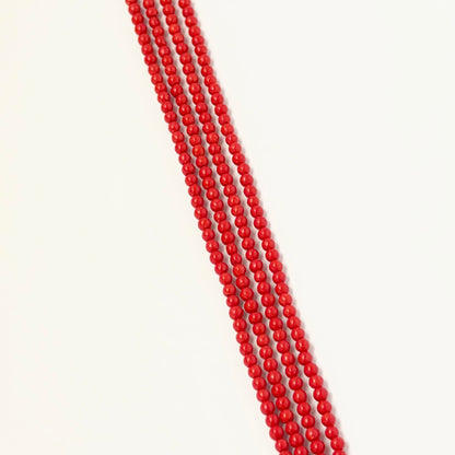 Taiwan Coral smooth round beads displayed on a strand to highlight their delicate size and coral tone.