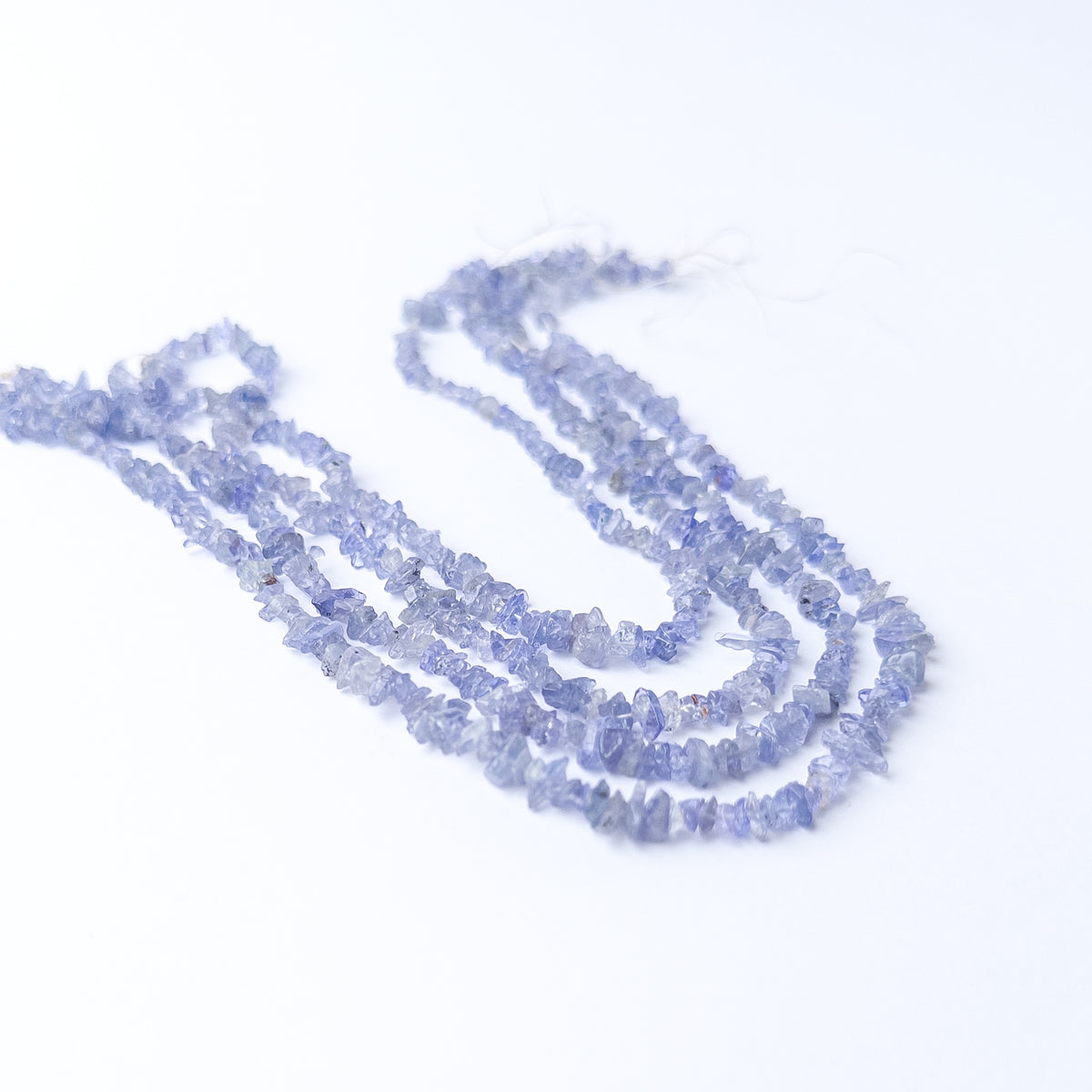 Tanzanite chip gemstone beads showing soft violet‑blue sparkle on a 29cm strand.