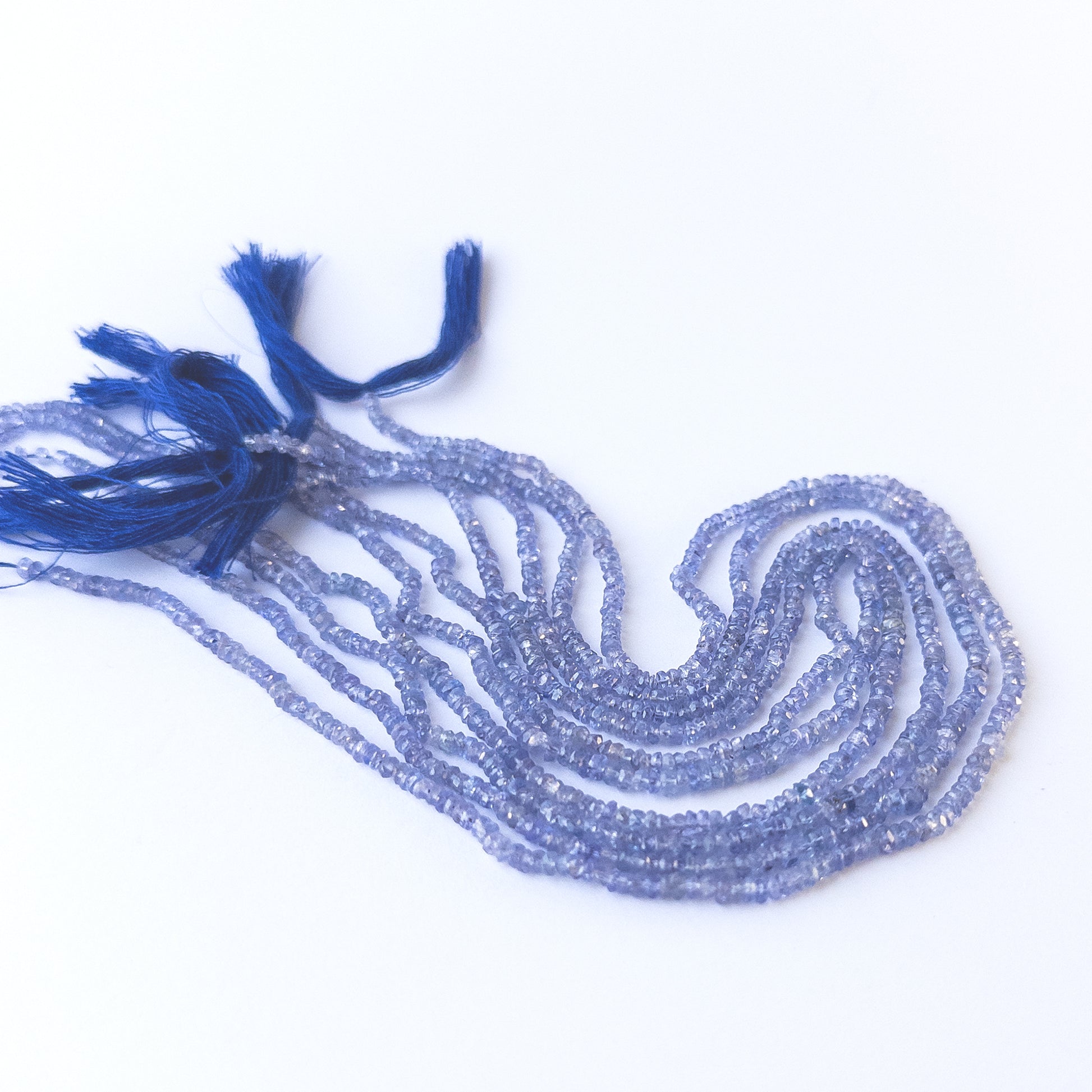 Tanzanite faceted rondelle gemstone beads in 2.6–3mm size arranged on a 32cm strand for handmade jewellery designs.
