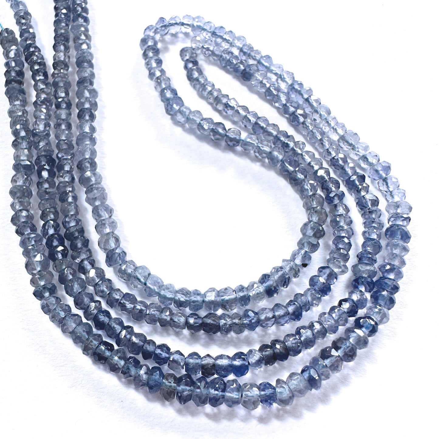 Close-up of 3.5mm tanzanite rondelle beads showing deep violet hues and precision faceting.