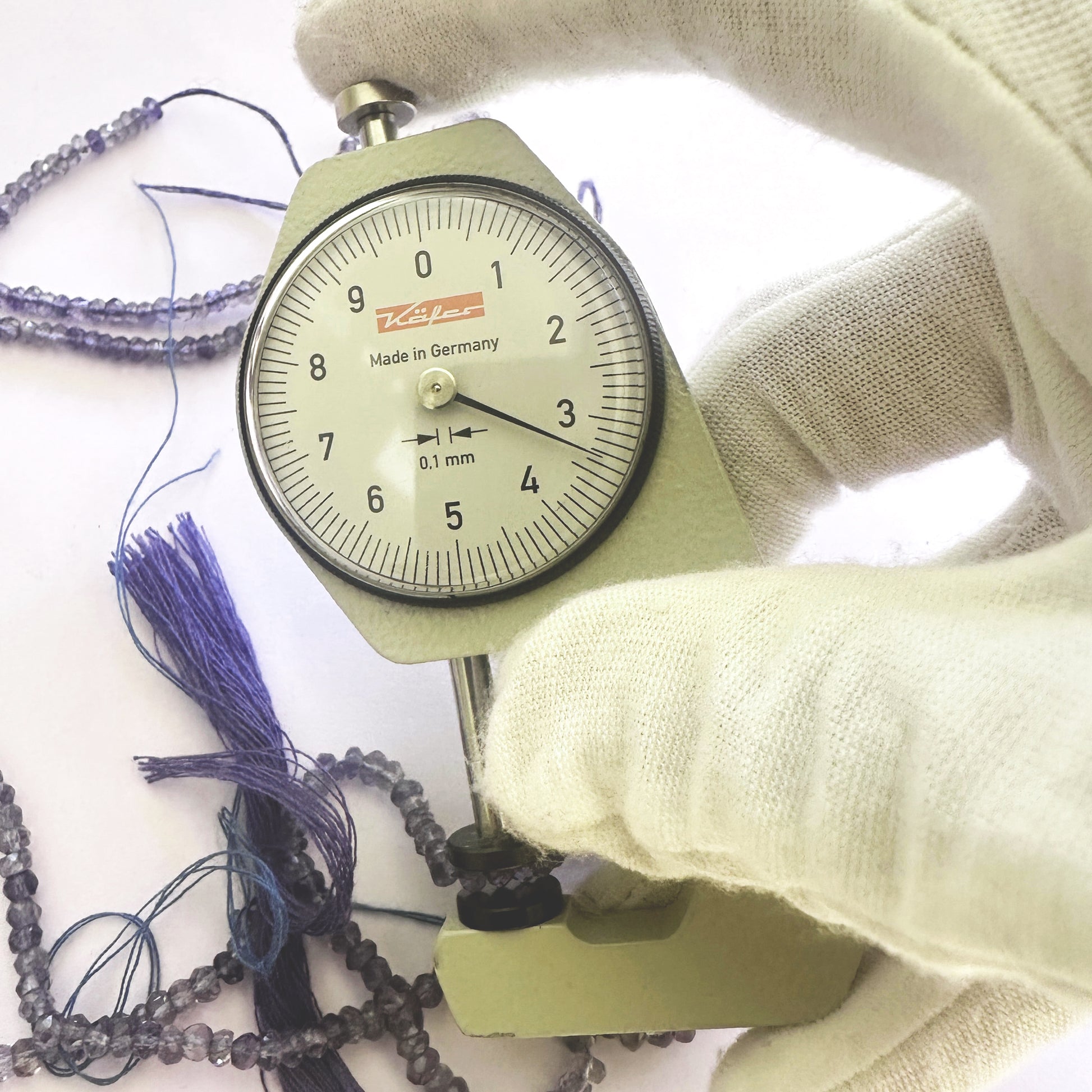 A dial gauge measures the Tanzanite faceted rondelle 3.5mm gemstone.