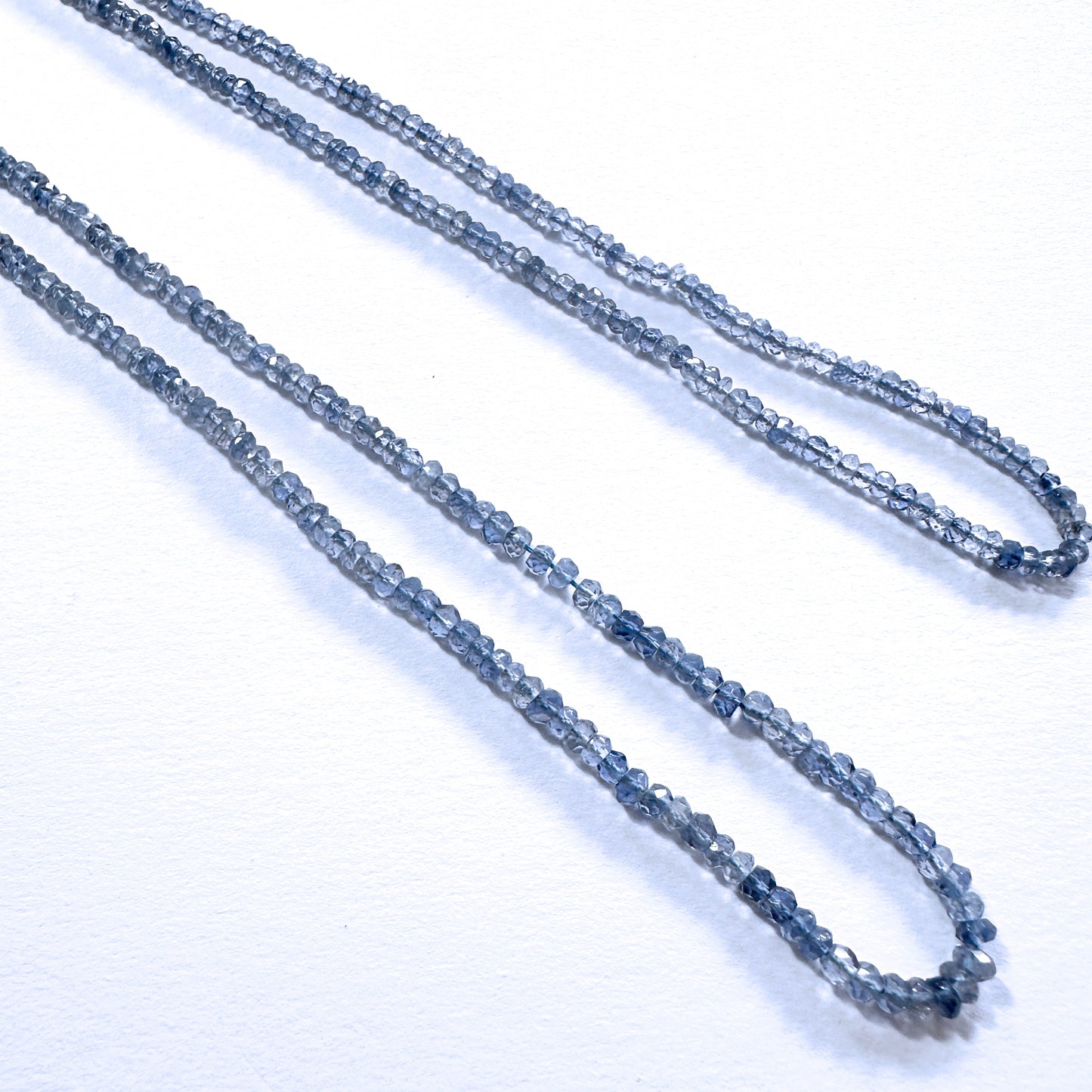 Vibrant faceted rondelle tanzanite beads in 3.1mm size sparkle across a neatly arranged 33cm strand.