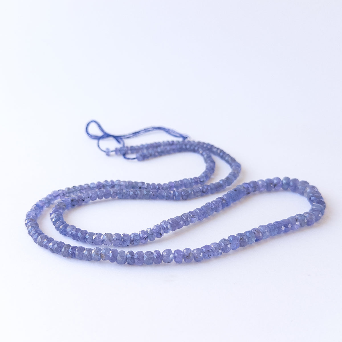 Authentic Tanzanite gemstone beads arranged on a strand, highlighting premium colour and clarity.