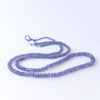 Authentic Tanzanite gemstone beads arranged on a strand, highlighting premium colour and clarity.