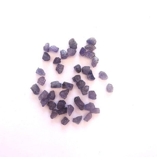 Loose rough Tanzanite gemstones with vivid violet-blue tones and natural texture.
