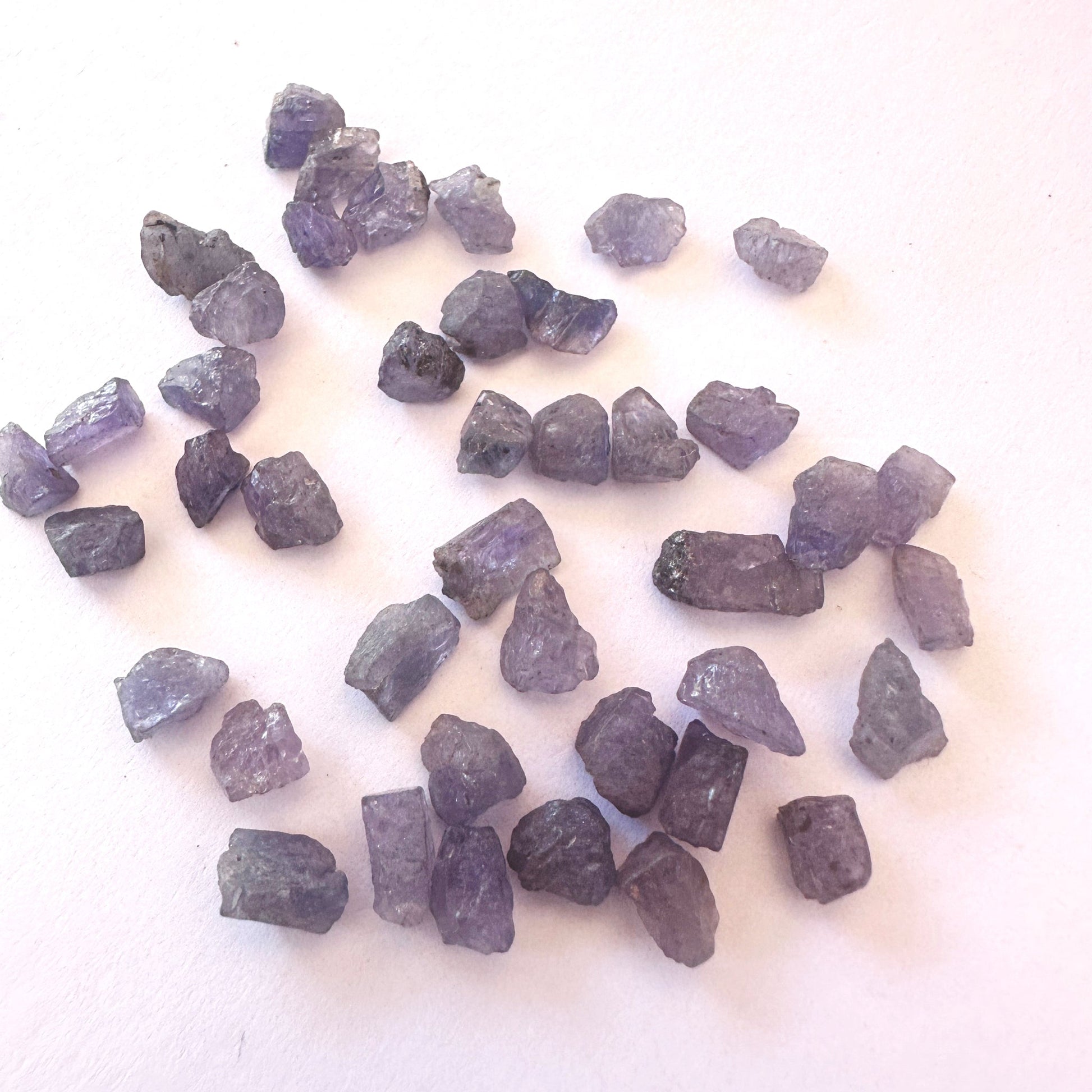 Uncut Tanzanite gemstones showing raw edges and shimmering blue-purple colour.