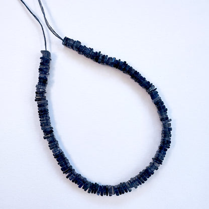 Natural gemstone beads in Tanzanite, arranged neatly on a strand for DIY jewellery.