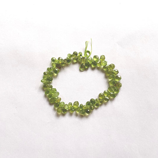 Vibrant green faceted Peridot pear-shaped briolette beads on a 20cm strand with eye-catching sparkle.