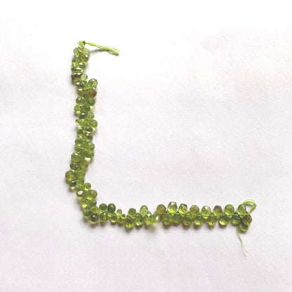 Faceted Peridot teardrop beads strung uniformly to highlight consistent size and shine.
