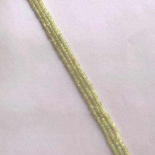 A strand of faceted Prehnite rondelle beads in soft green tones, arranged neatly on a 33cm string.