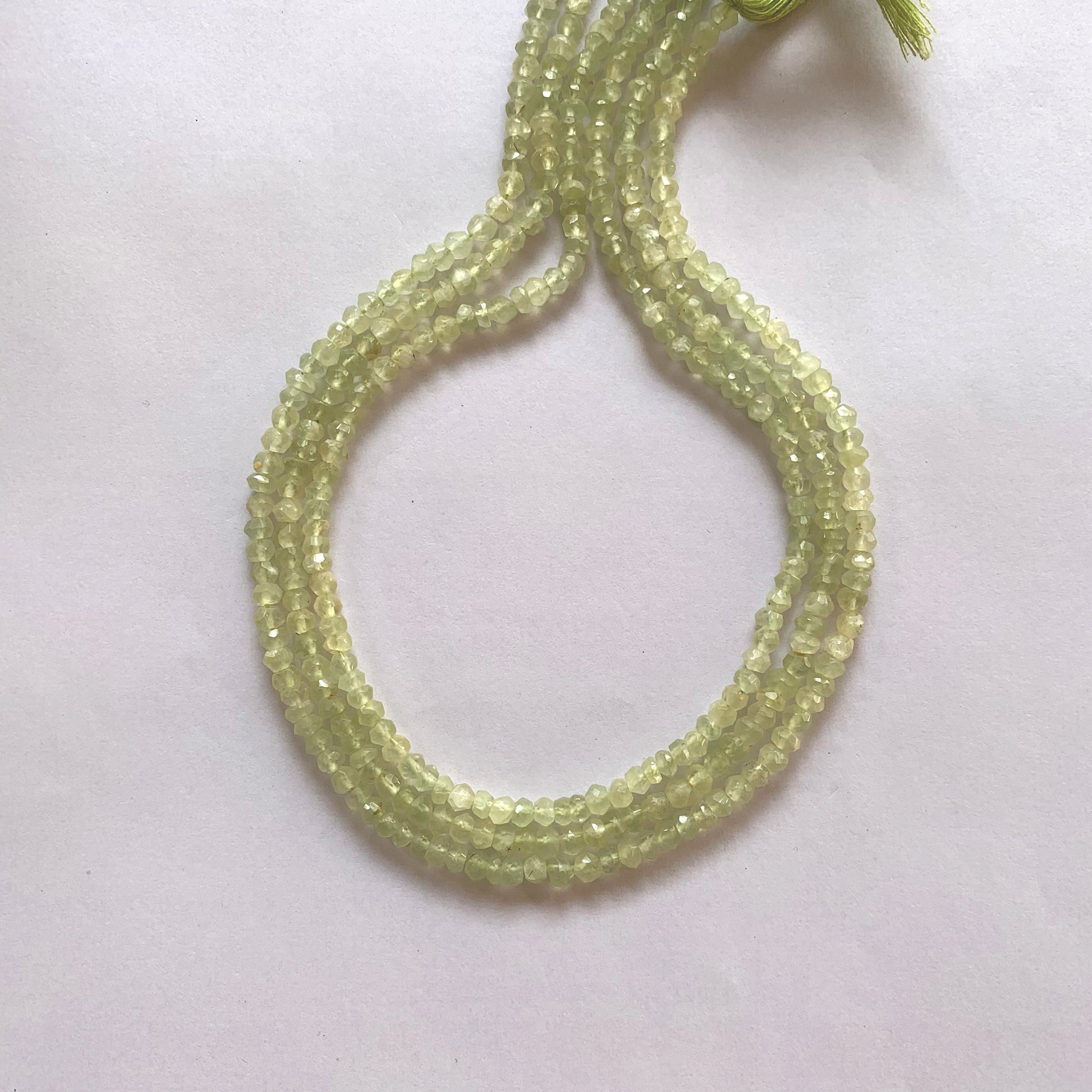 Close-up of Prehnite gemstone beads showing their 4.0–4.2mm size and brilliant faceted cut.