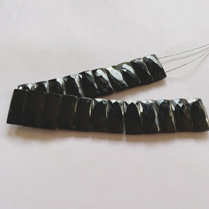 Macro shot of Black Onyx faceted rectangle gemstones showing uniform shape and high shine.