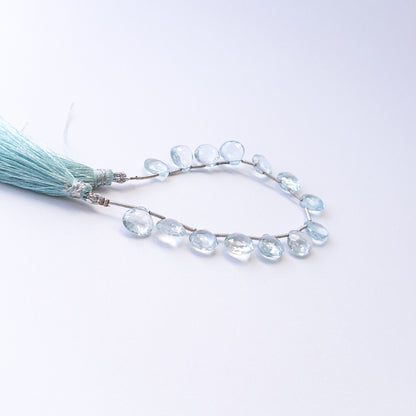 Genuine Topaz gemstone beads showcasing faceted briolette cuts arranged neatly in 14‑piece sets.