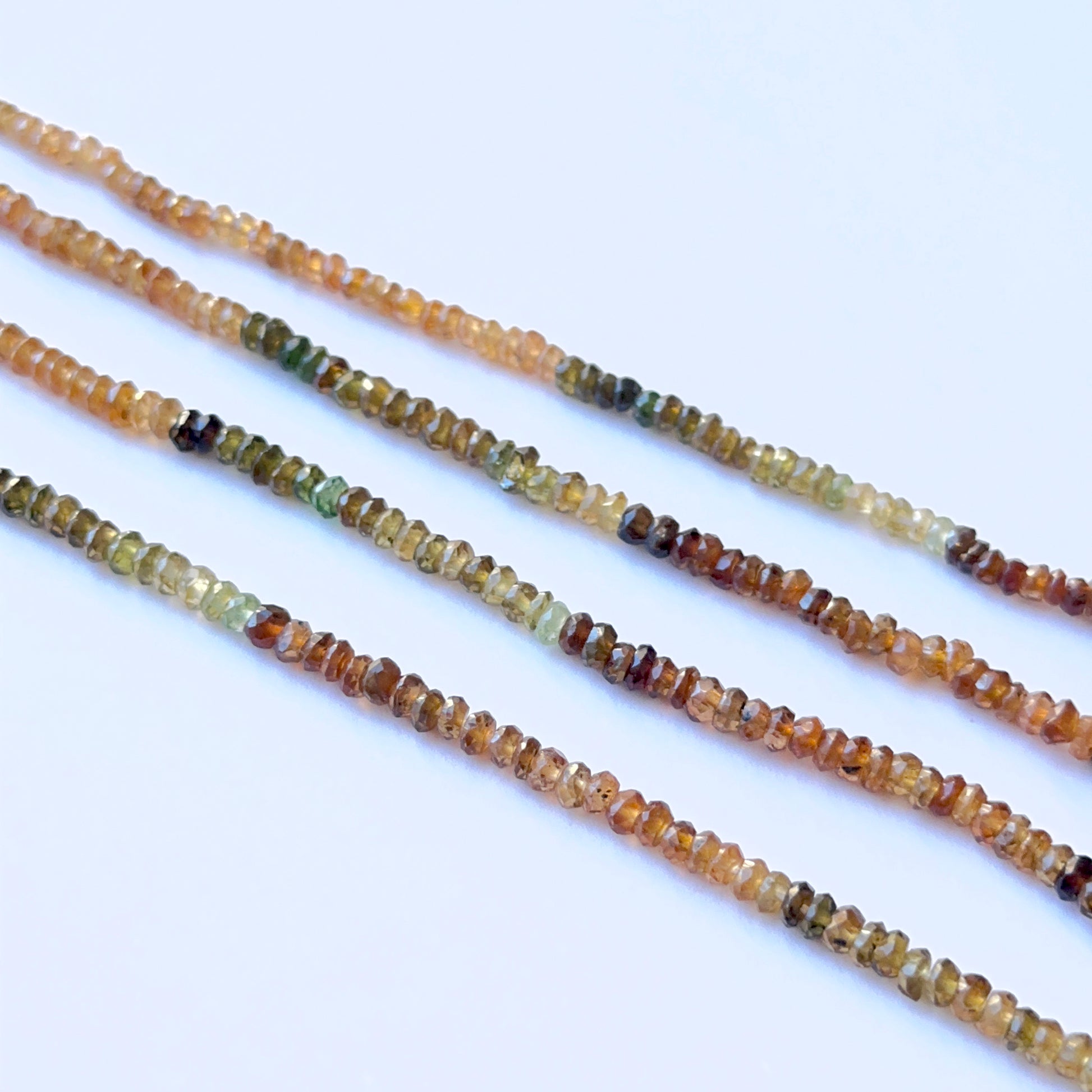 Tourmaline faceted rondelle 3–3.5mm natural gemstone beads on a 36cm strand showing brown, orange and green tones.