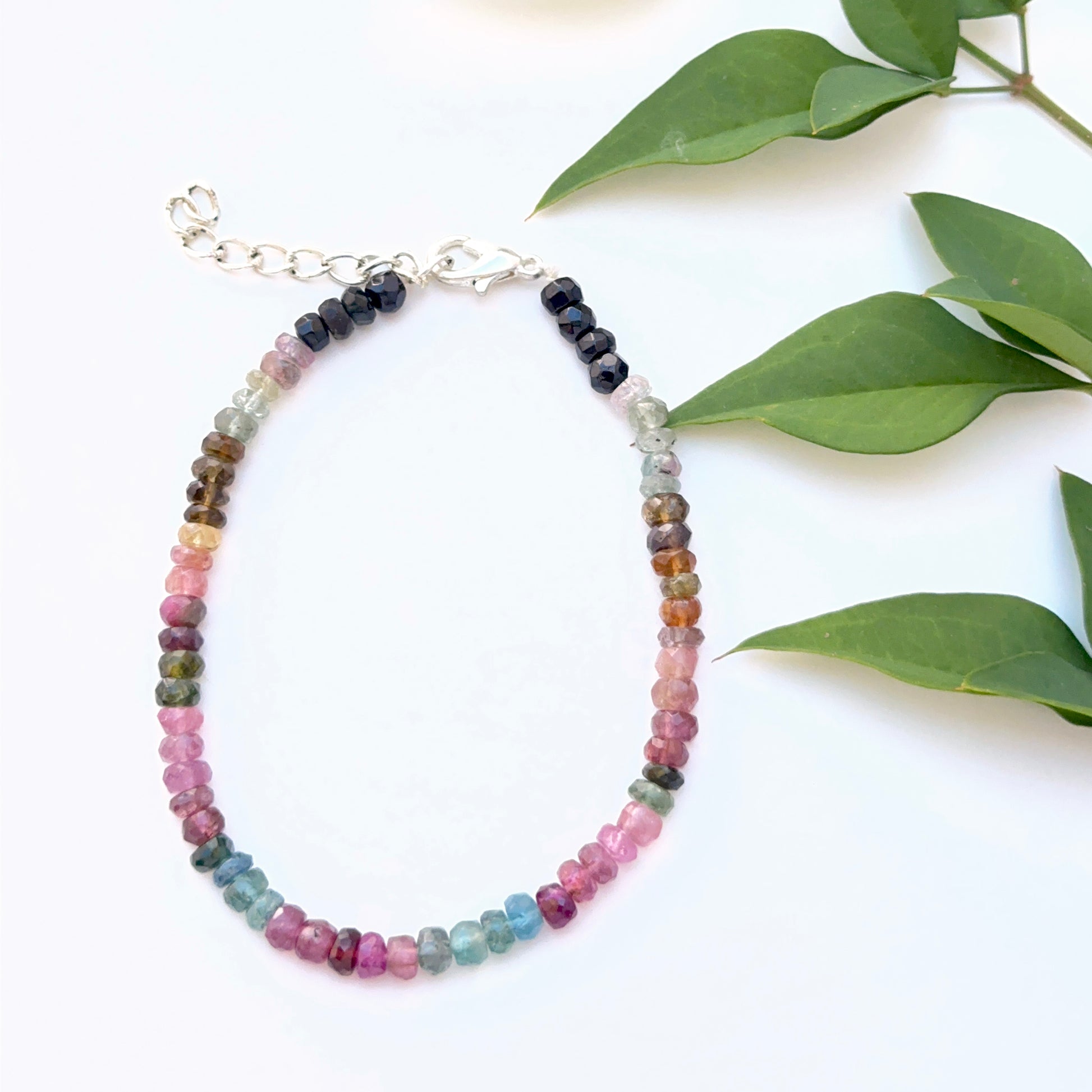 Close‑up of faceted tourmaline beads arranged on a polished bracelet.