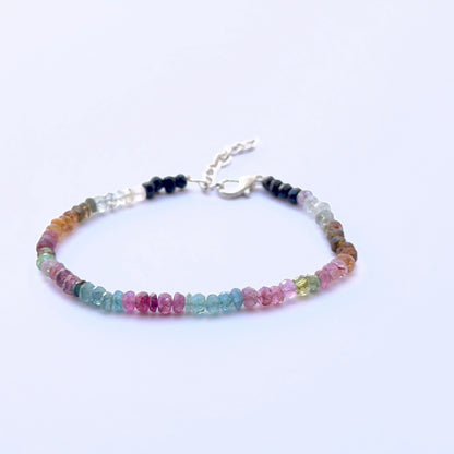 Close‑up of 4mm faceted tourmaline beads arranged on a polished bracelet.