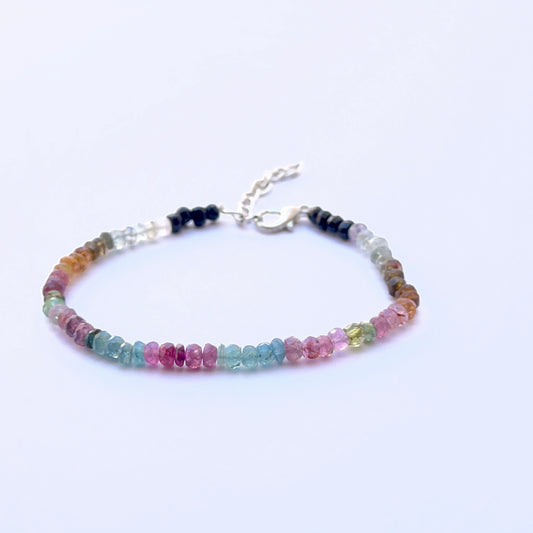 Close‑up of 4mm faceted tourmaline beads arranged on a polished bracelet.