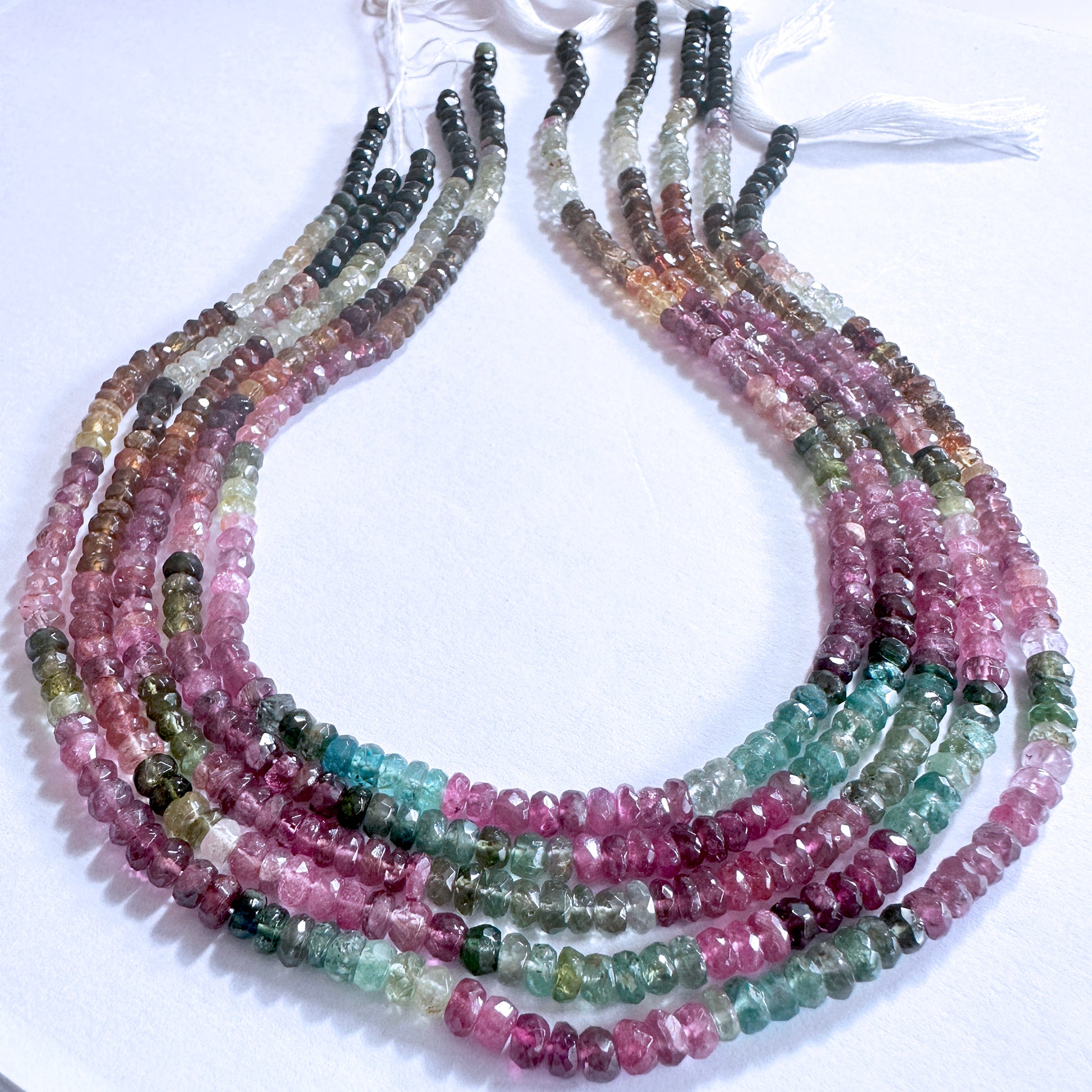 Close-up of Tourmaline gemstones with faceted rondelle cut, arranged in a 34cm strand with vibrant clarity and polish.