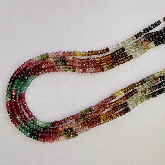 Close-up of Tourmaline beads showing multi-tonal sparkle and precision faceting.