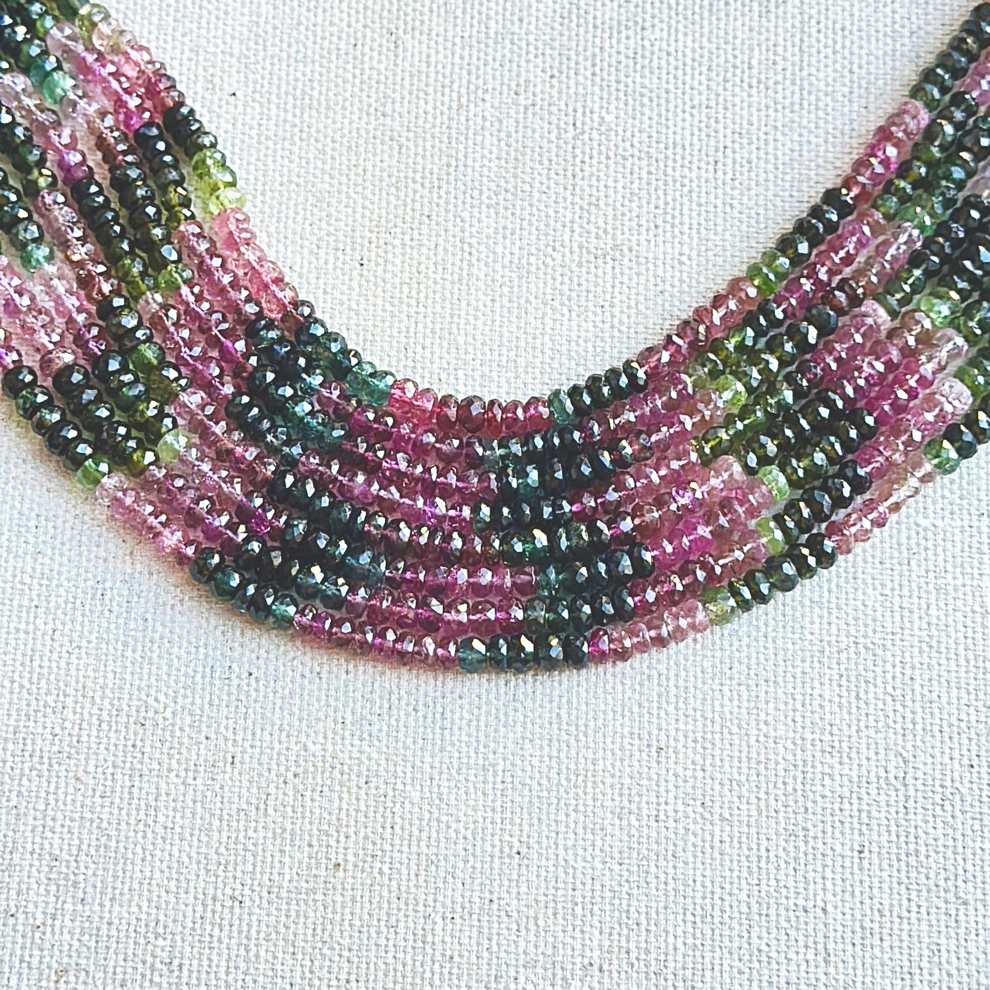 Tourmaline faceted rondelle beads in 4.8mm–5.7mm sizes, arranged in a vibrant multicolour strand with brilliant polish.