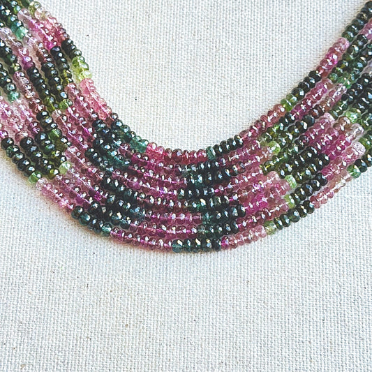 Tourmaline faceted rondelle beads in 4.8mm–5.7mm sizes, arranged in a vibrant multicolour strand with brilliant polish.