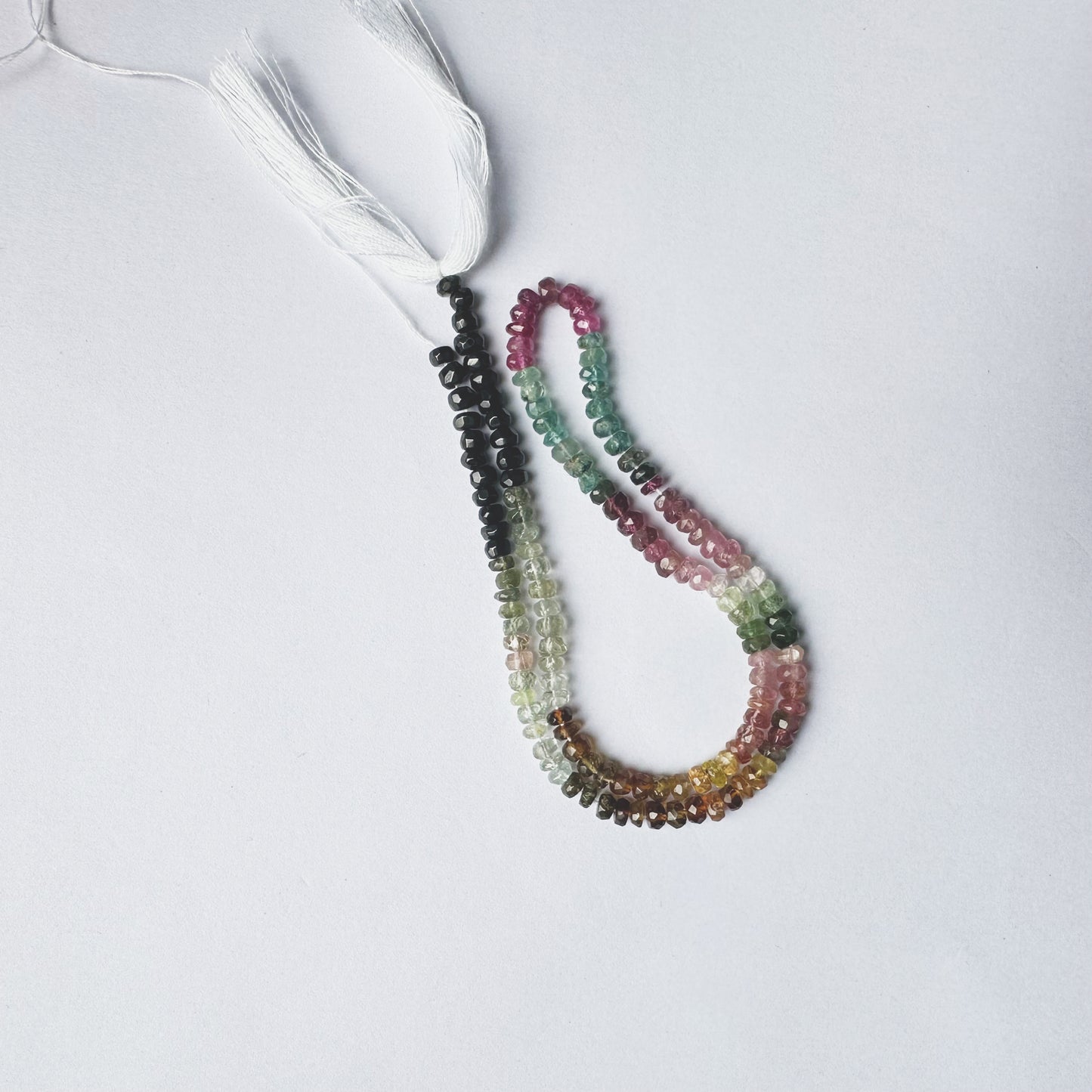 Natural gemstone beads in Tourmaline, faceted rondelle cut, 4mm size, arranged on a 32cm strand.