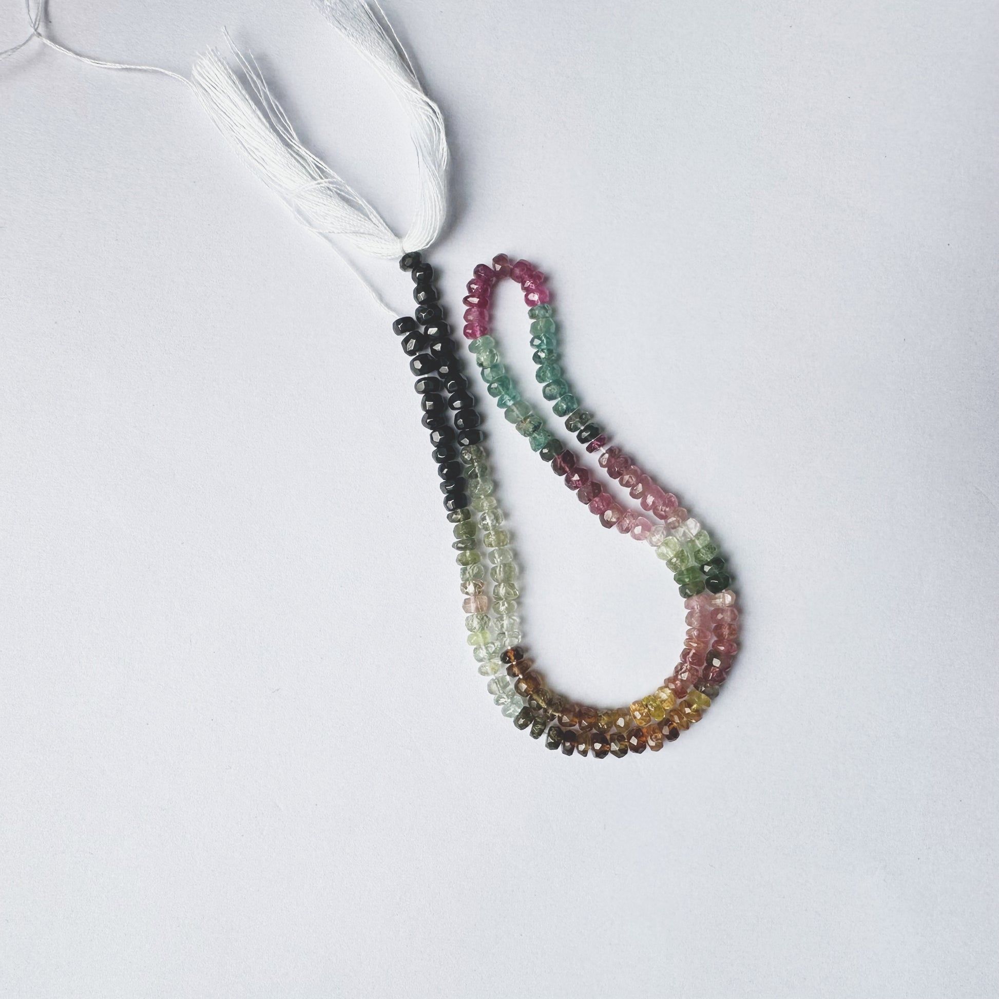 Natural gemstone beads in Tourmaline, faceted rondelle cut, 4mm size, arranged on a 32cm strand.
