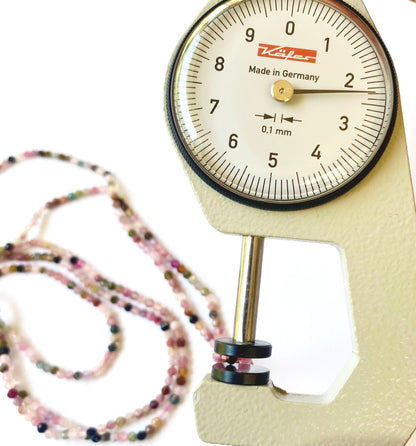 A dial gauge measures the Tourmaline micro faceted 2.3mm gemstone
