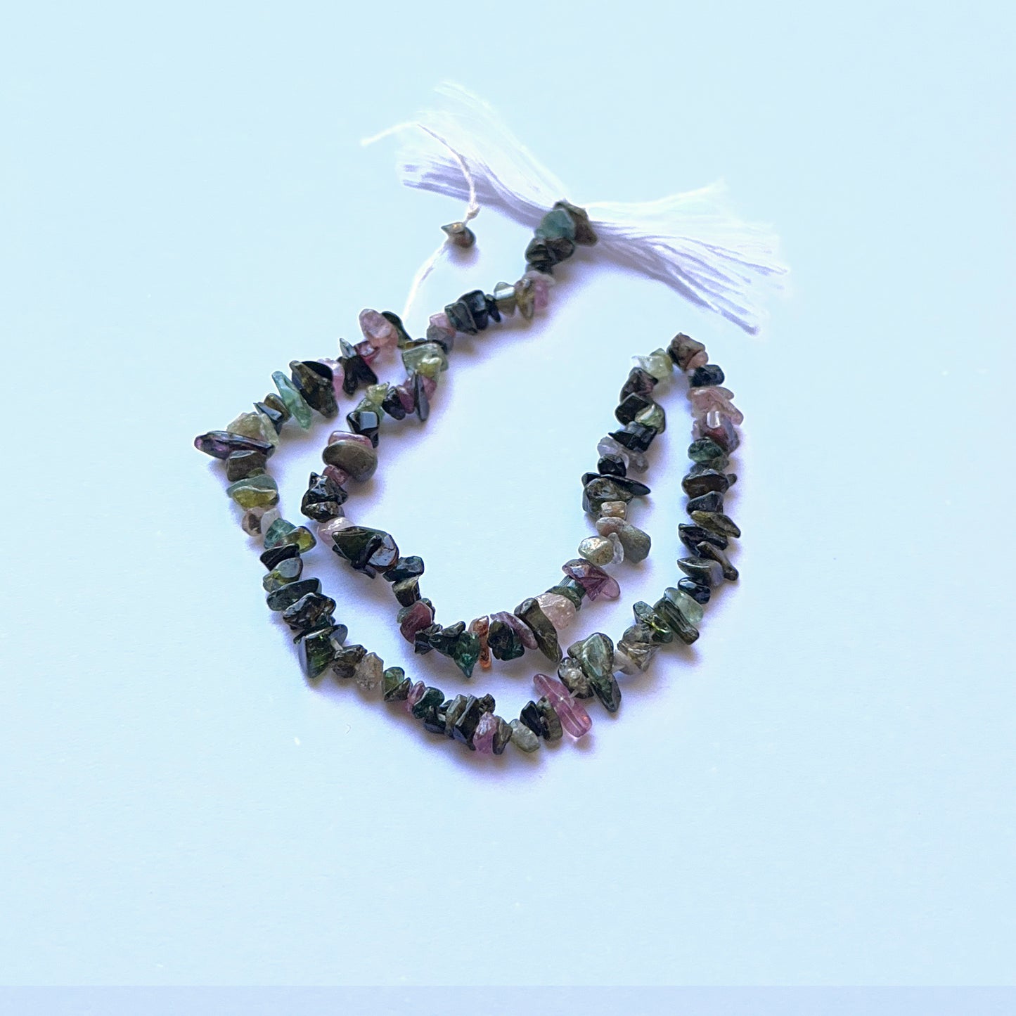 Tourmaline rough chip natural gemstone beads in mixed earthy colours arranged on a 25cm strand for handmade jewellery components.