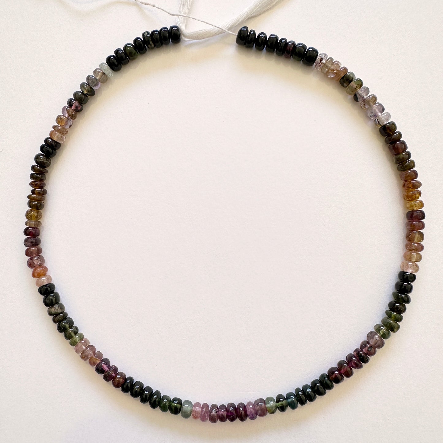 Tourmaline gemstones in 5.5mm smooth rondelle cut, laid out to highlight clarity and colour variation.