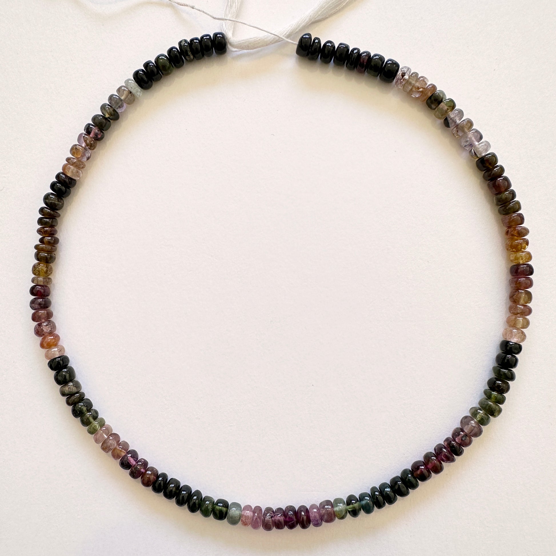 Tourmaline gemstones in 5.5mm smooth rondelle cut, laid out to highlight clarity and colour variation.