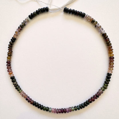 Tourmaline gemstones in 5.5mm smooth rondelle cut, laid out to highlight clarity and colour variation.