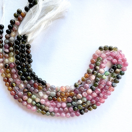 Tourmaline smooth round beads in 4.3-4.7mm size, arranged on a 31cm strand with polished finish and vibrant tones.