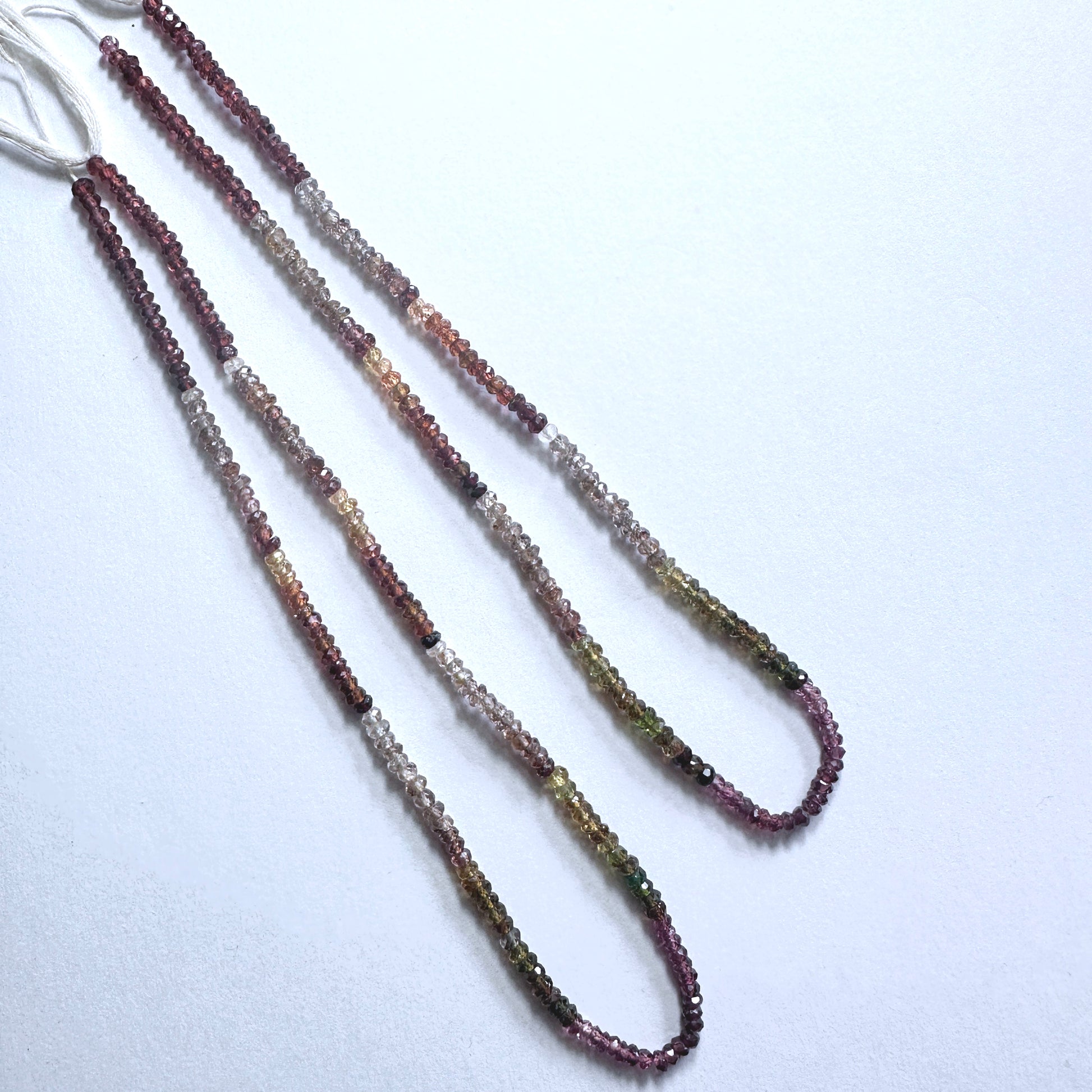 Faceted Tundra Sapphire beads with muted green and grey hues in a polished 33cm arrangement.