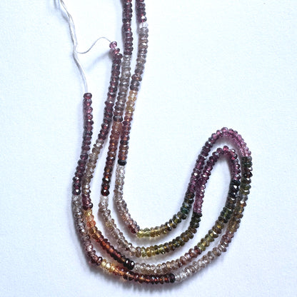 Tundra Sapphire gemstone beads in faceted rondelle cut reflect light with organic brilliance.