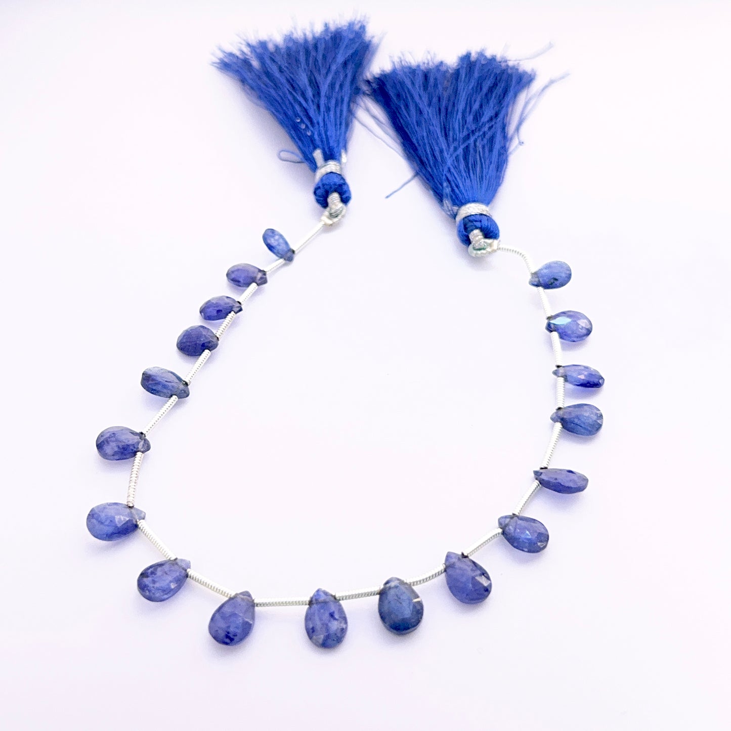 Blue Sapphire pear faceted almond beads 7–9mm, 18 pieces, 33 carats, showing deep royal blue sparkle for jewellery making.
